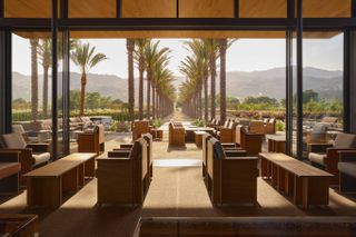 Open seating area in Caymus-Suisun Winery in California, looking out to palm trees