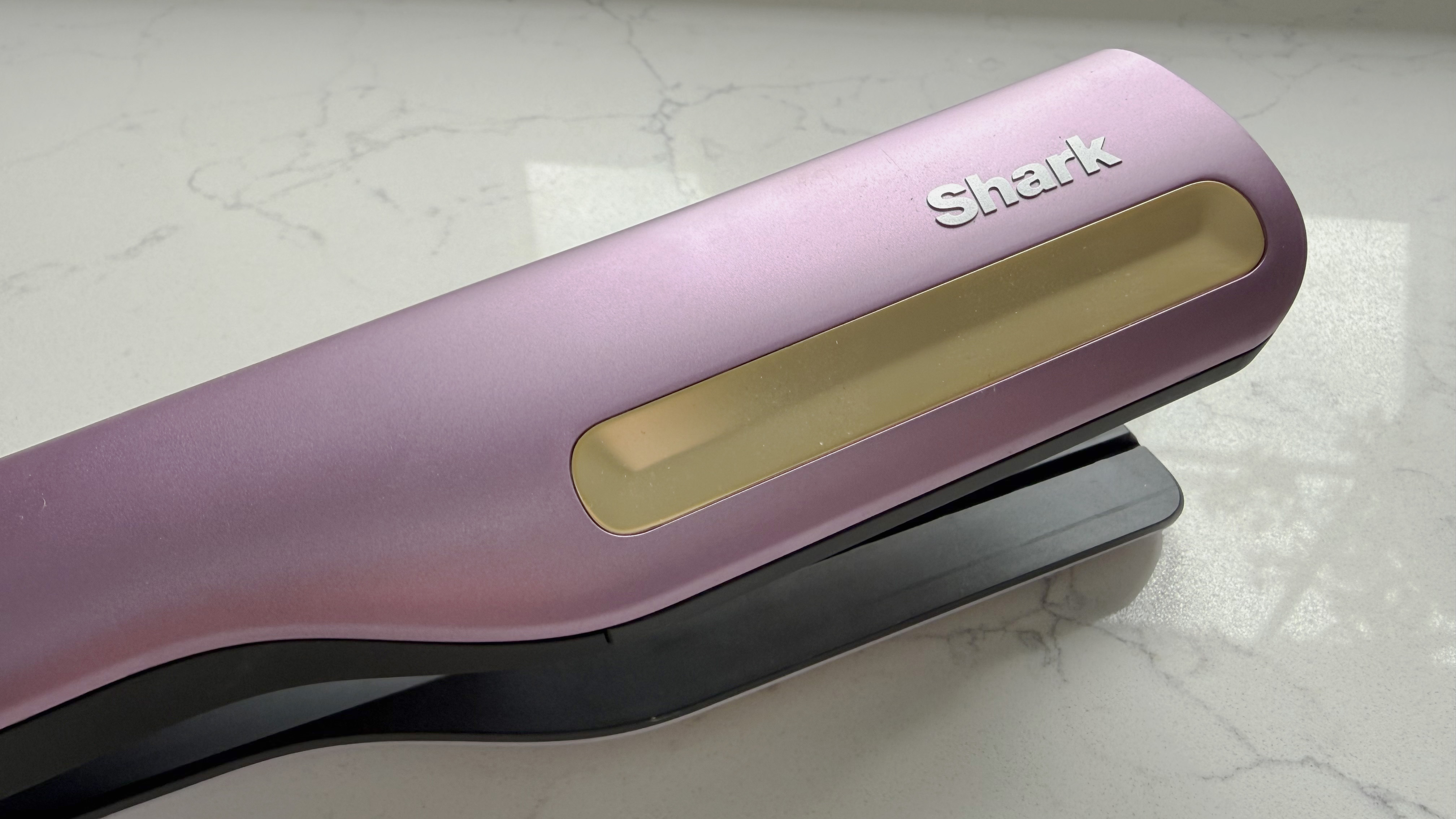 Close-up of the gold cool-touch strip on the top of the Shark SilkiPro Straight body with the Shark logo