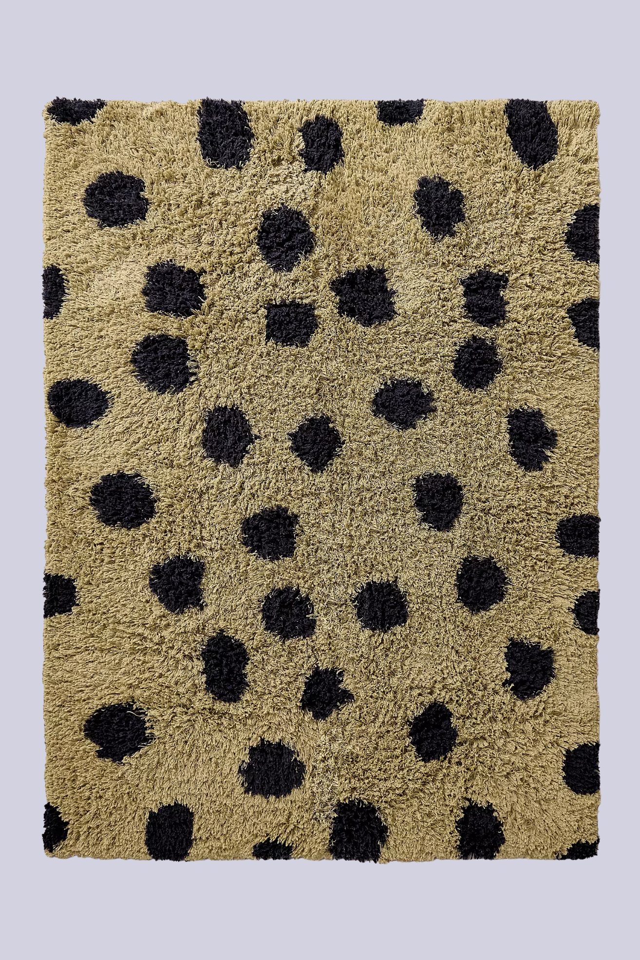 A khaki fuzzy rug with black spots