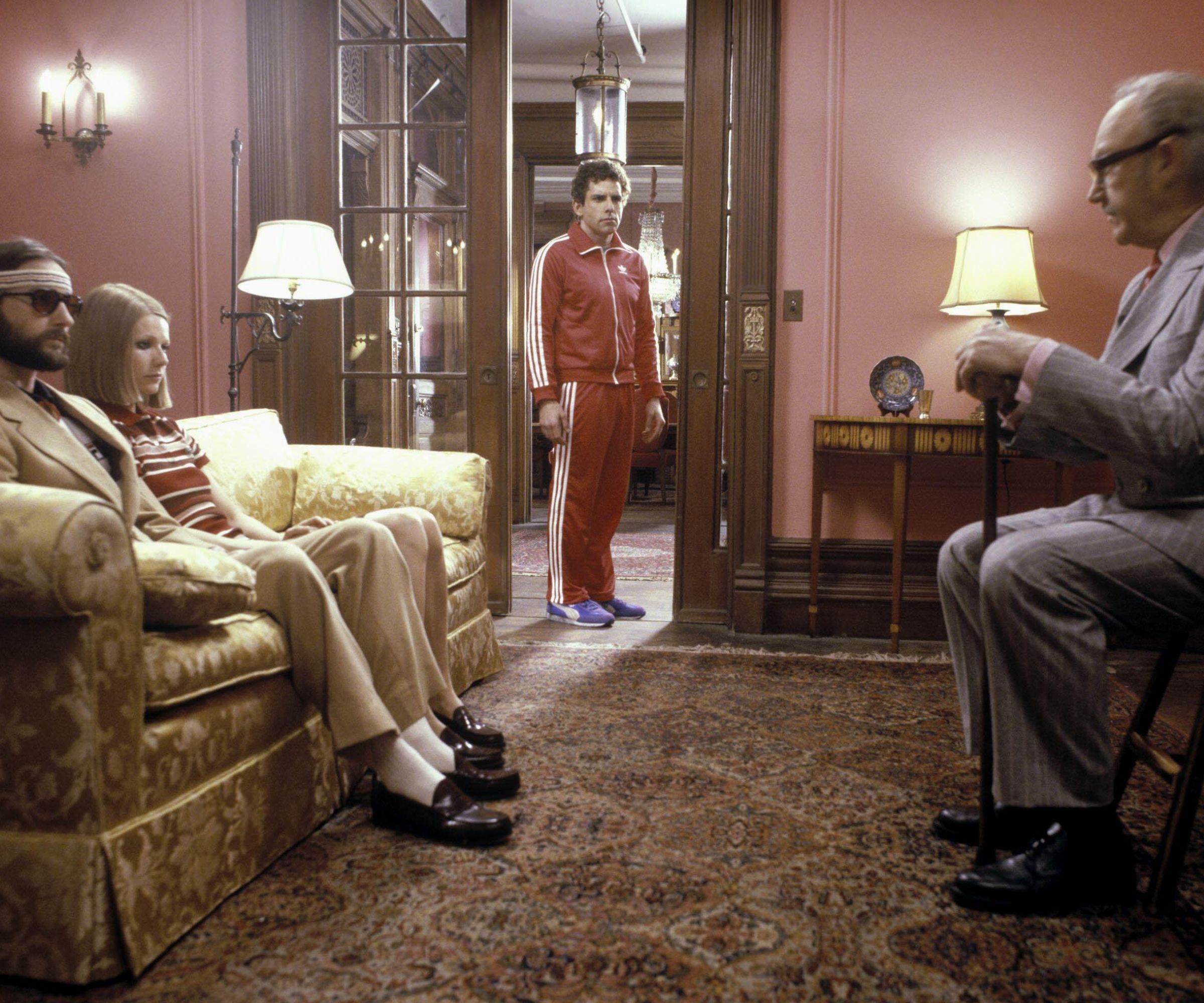 Gwyneth Paltrow, Ben Stiller and Owen Wilson in Living room with pink walls, patterned carpet and yellow upholstered sofa