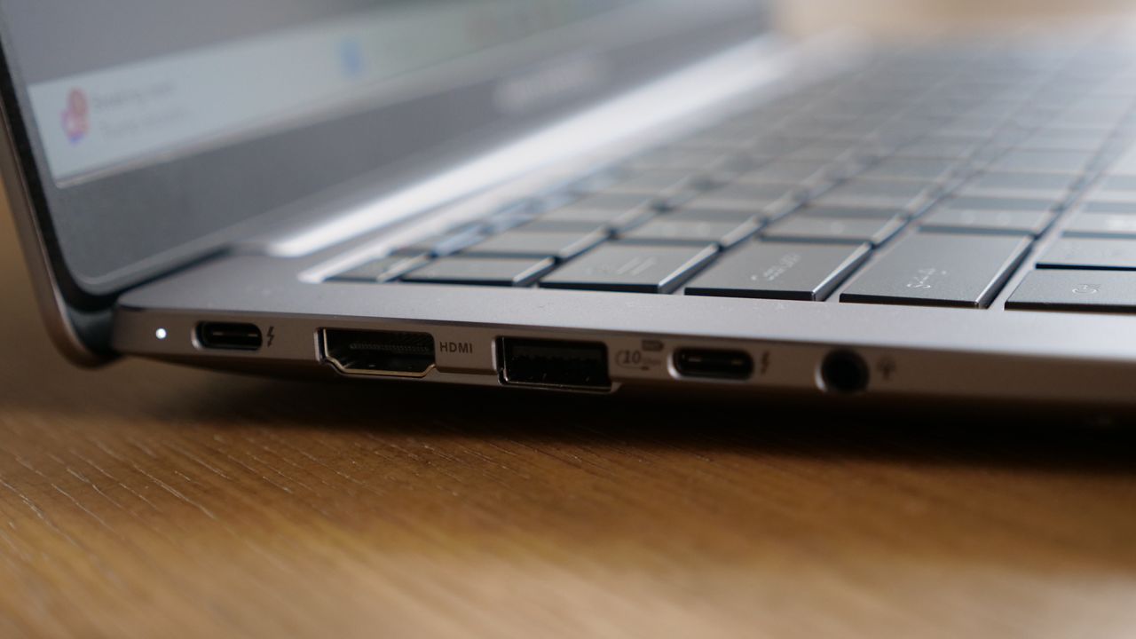 Sideview of Asus ExpertBook P5 (P5405) open on a wooden table focused on its ports