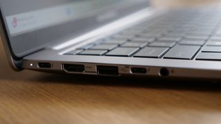 Sideview of Asus ExpertBook P5 (P5405) open on a wooden table focused on its ports