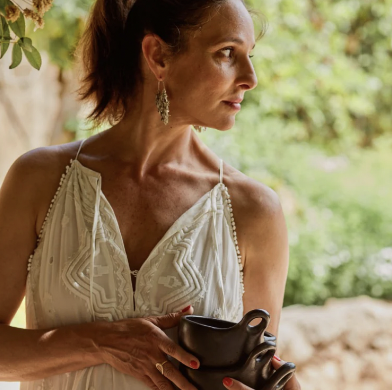 A woman with dark hair wearing a white sun dress