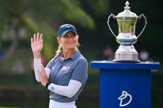 Bailey Tardy waves at the crowd while stood next to the Blue Bay LPGA trophy in China