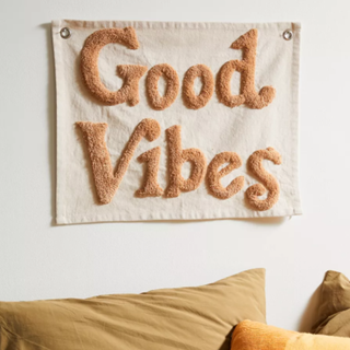 A tapestry with 'good vibes' hanging on the wall