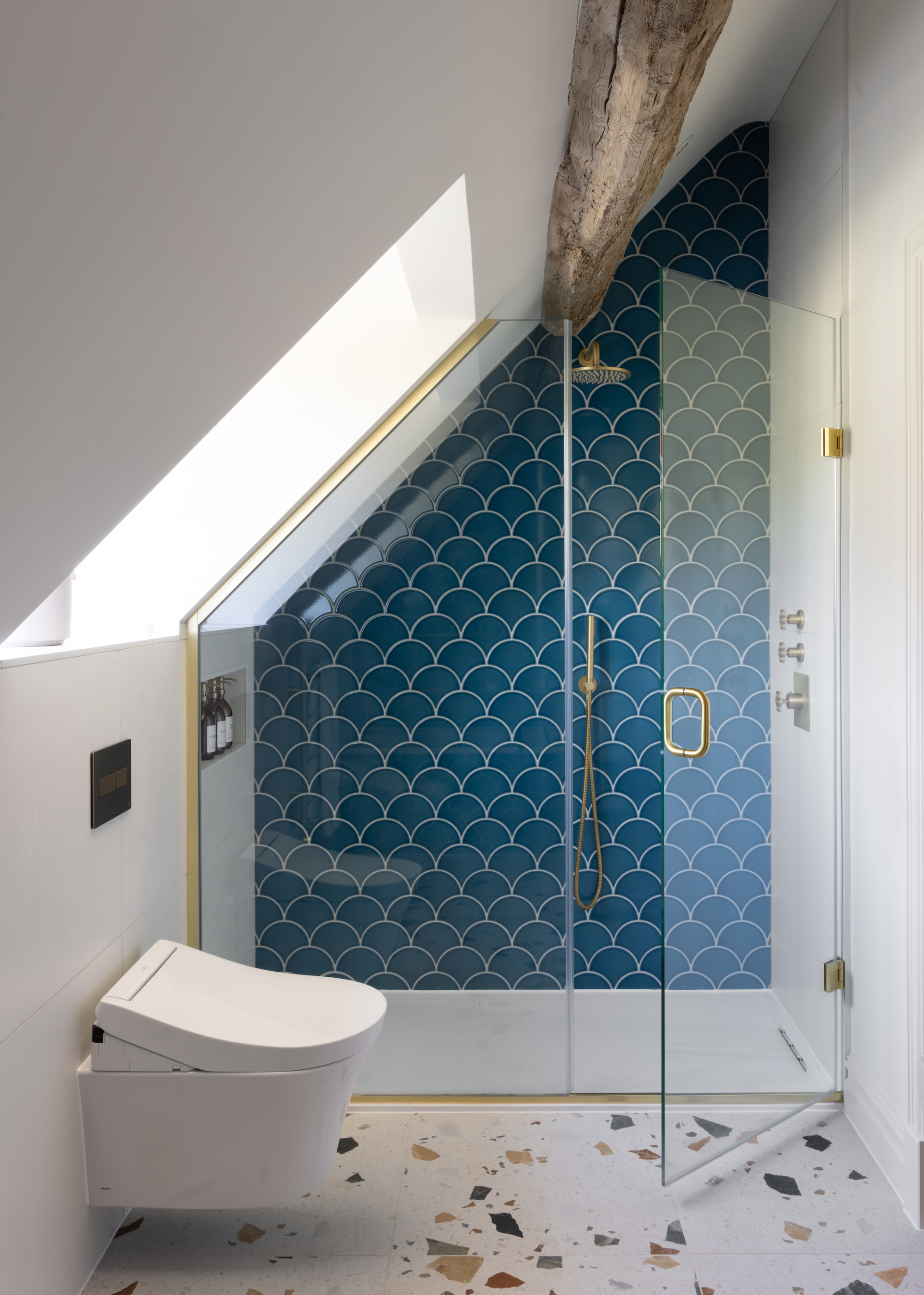 shower with blue fishscale tiles and terrazzo floors