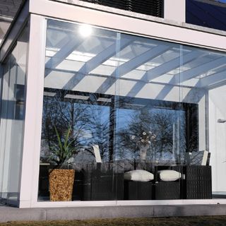 Small conservatory windows with white frames with seating