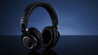 Pair of Audio Technica headphones on a dark blue background