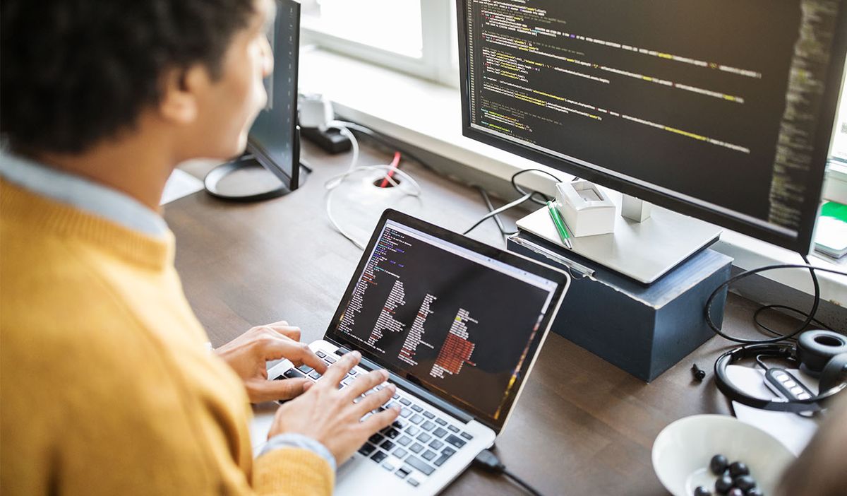 A man coding on a laptop on one of the best online coding courses