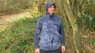 Man wearing Arc'teryx Gamma Lightweight Hoody with hood up in the woods