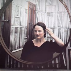 Michelle McNamara reflected in a round mirror.