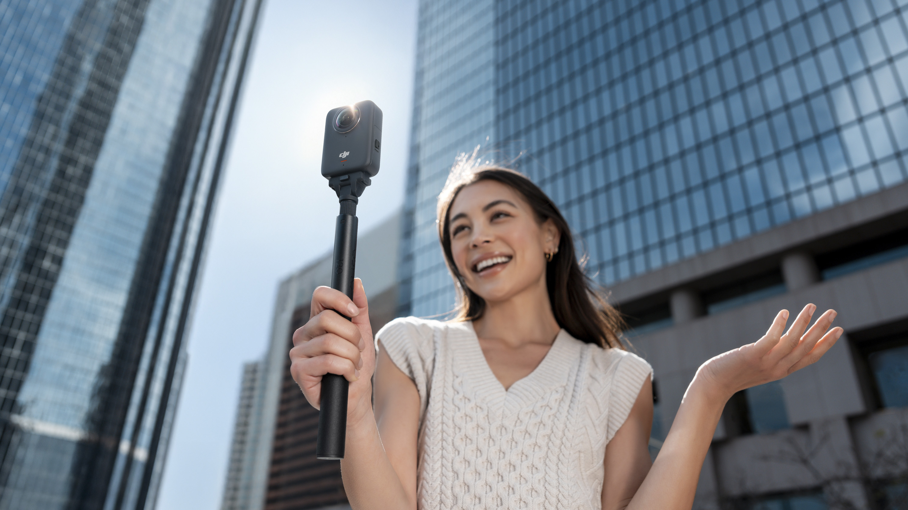 User vlogging with the DJI Osmo 360 camera on a selfie stick