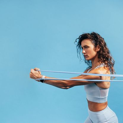 A woman doing one of the best resistance band core workouts for beginners outside