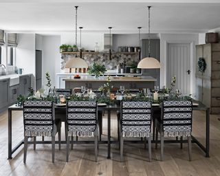 Kitchen Christmas decor ideas with a dining table laid with green decor in an open plan kitchen diner