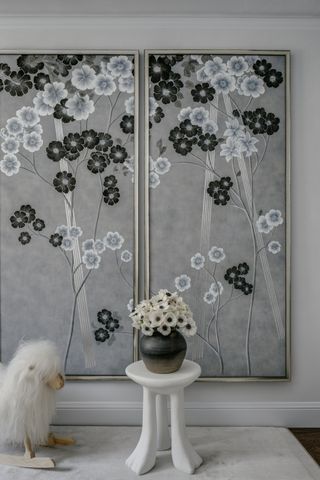 A room with three wall papered wall panels with a black and white flower motif