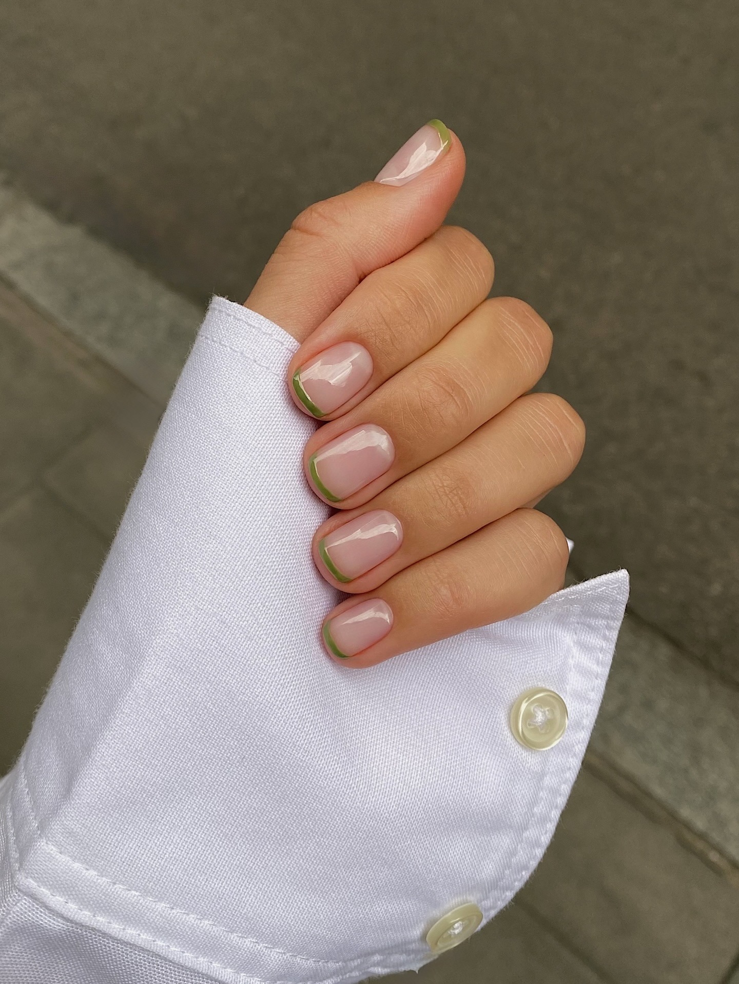 A short French manicure with green French tips