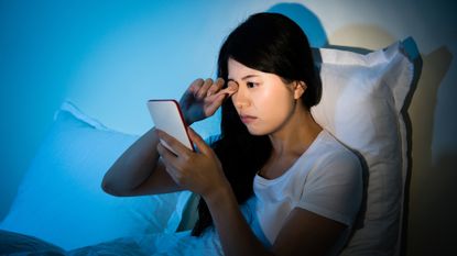 Woman using her phone in bed