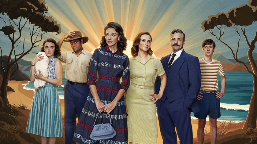 The cast of Ten Pound Poms standing in a row for a press shot, with a beach sunset behind them 