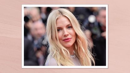 Sienna Milller is pictured with blonde wavy hair and a dark rosy lipstick look while attending the "Horizon: An American Saga" Red Carpet at the 77th annual Cannes Film Festival at Palais des Festivals on May 19, 2024 in Cannes, France in a pink template