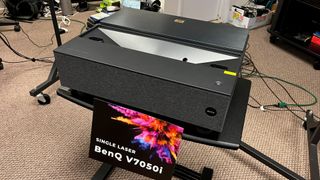 BenQ V7050i laser projector on table with sign