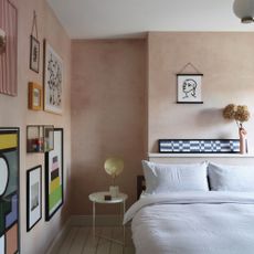 Bedroom with limewashed walls and bed with white bedding and gallery wall