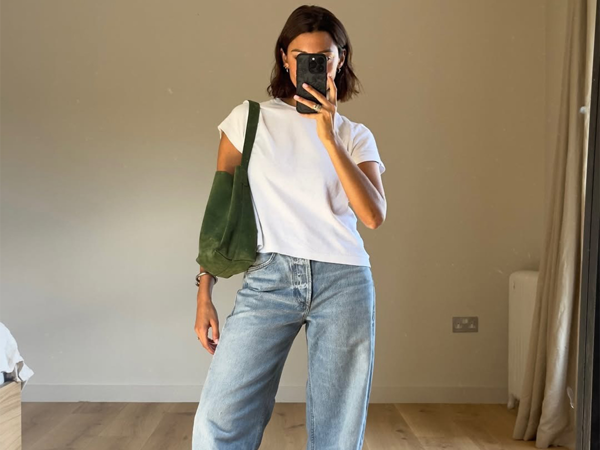 Influencer Marianne wears a basic white tee and light-wash jeans with a suede green tote.