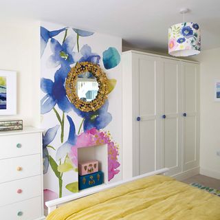 bedroom with floral wallpapers on cupboard and wooden flooring
