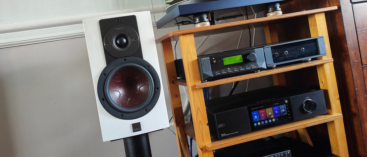 The DALI Rubikore 2 speaker in white next to a wooden surface