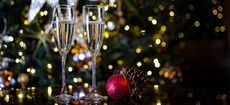 Two Champagne Glasses surrounded by Christmas Decorations