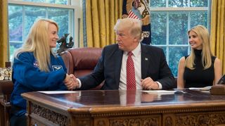 President Donald Trump shakes hands with NASA astronaut Kate Rubins in the Oval Office of the White House during a video conference with NASA astronauts Peggy Whitson and Jack Fischer at the International Space Station on Monday, April 24, 2017.