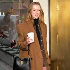 Phoebe Dynevor wears a roll neck knit underneath a jacket and coat.