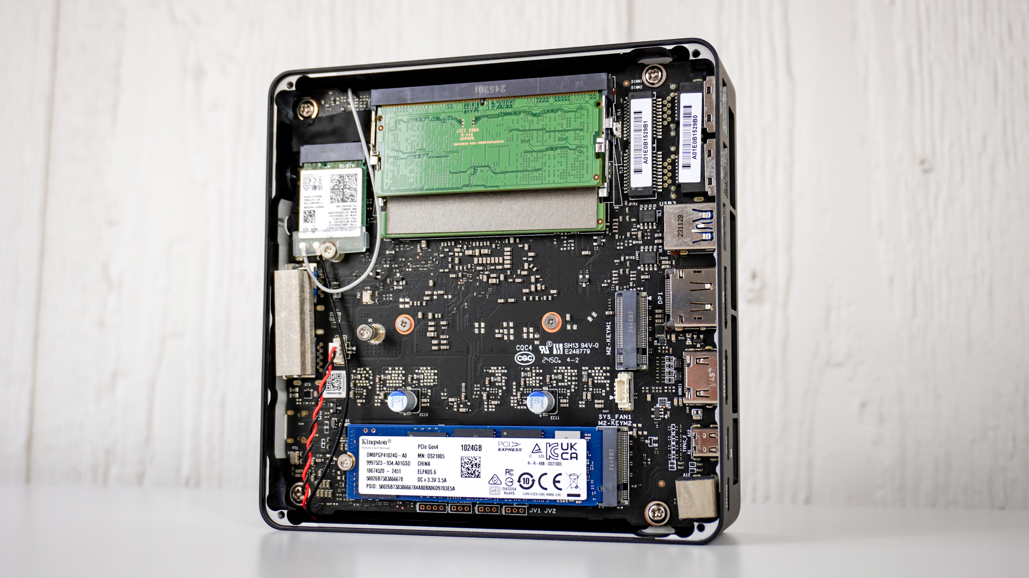 The Minix Elite EU715-AI opened on a table showing its free M.2 slot and other internals