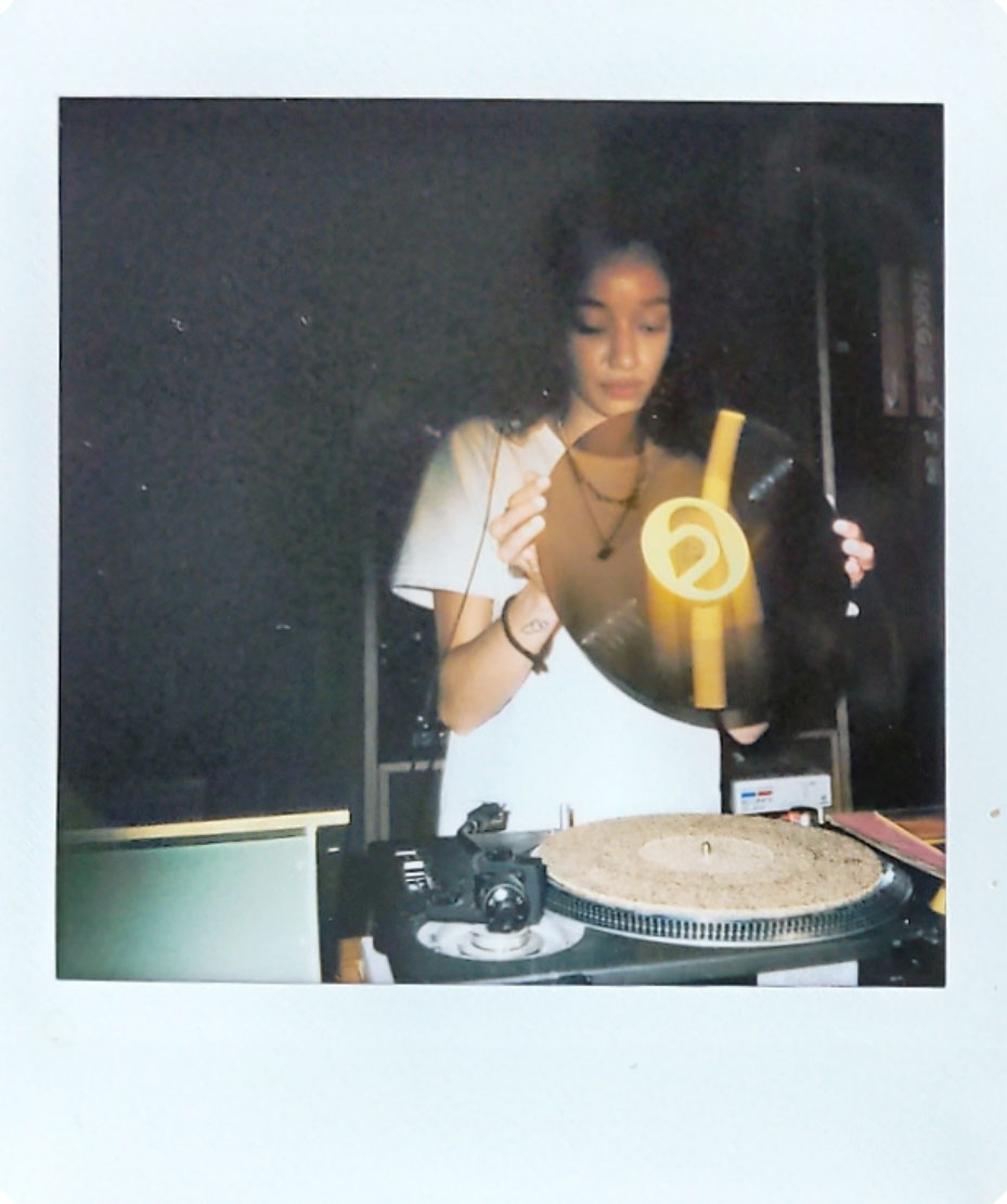 Digitized instant photo taken with the Fujifilm Instax SQ40 of DJ indoors in darkly lit bar