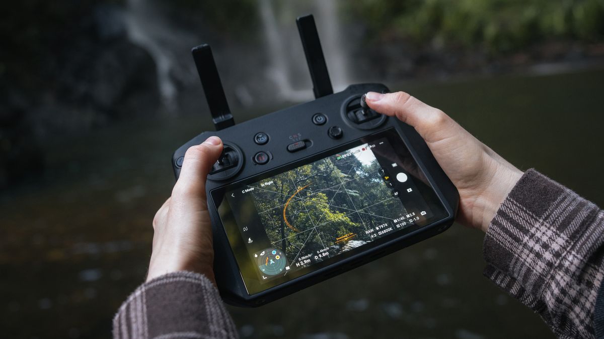 Two hands holding a DJI drone controller