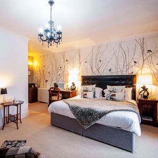 bedroom with bird-print wallpaper and matching soft furnishings