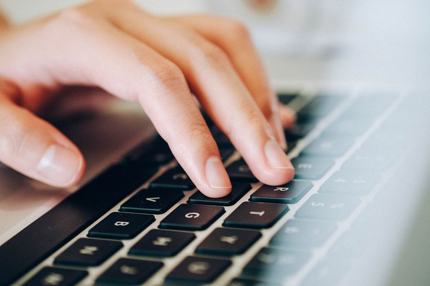 Fingers typing on a laptop keyboard.