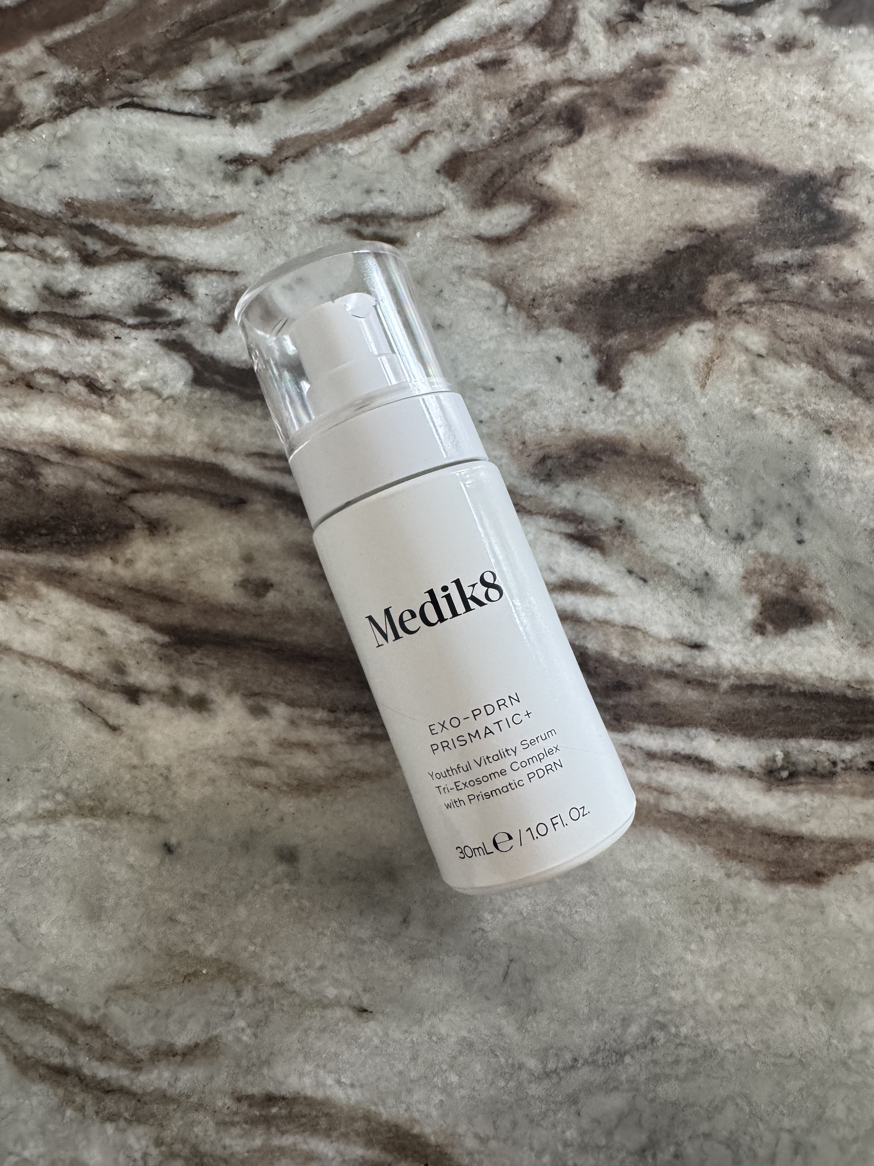 A photo of the Medik8 Exo-PDRN Prismatic+ serum on a marble table