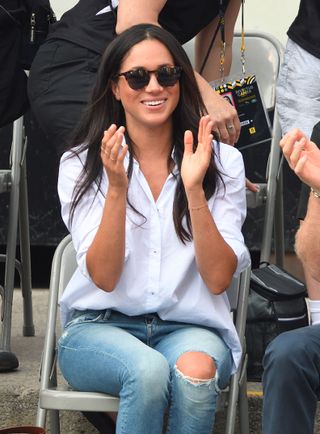 Meghan Markle wears ripped jeans and a button down shirt at the Invictus Games with Prince Harry