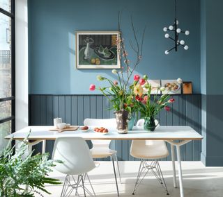 A dining room with white dining set and two-toned blue wall