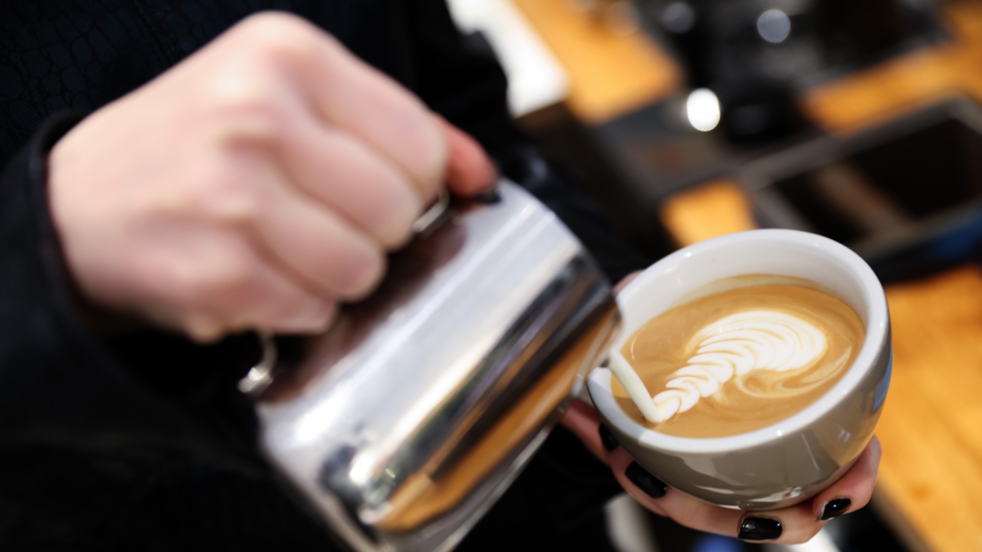 A barista pours coffee at a coffeehouse in Berlin. 