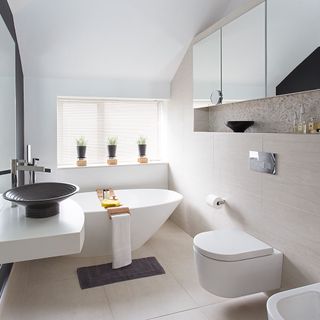 white bathroom with bathtub and black washbasin