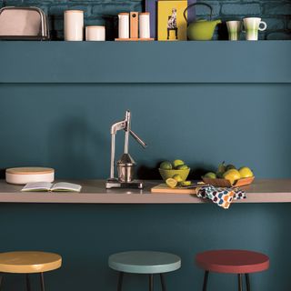 blue wall with table and stools and fruit and lemons
