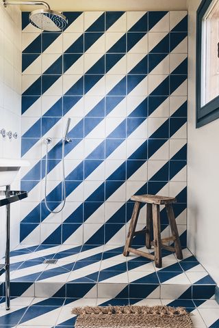 Light filled shower with diagonal blue and white striped tiles