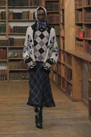 Anna Sui model wearing argyle sweater, printed cardigan, and plaid skirt