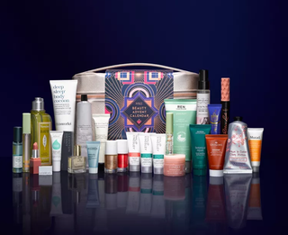Beauty products lined up behind a makeup bag on purple background