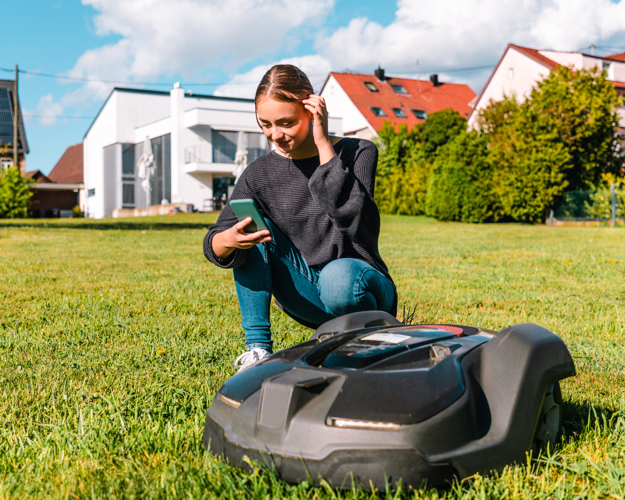 Girl setting up robot lawn mower on phone