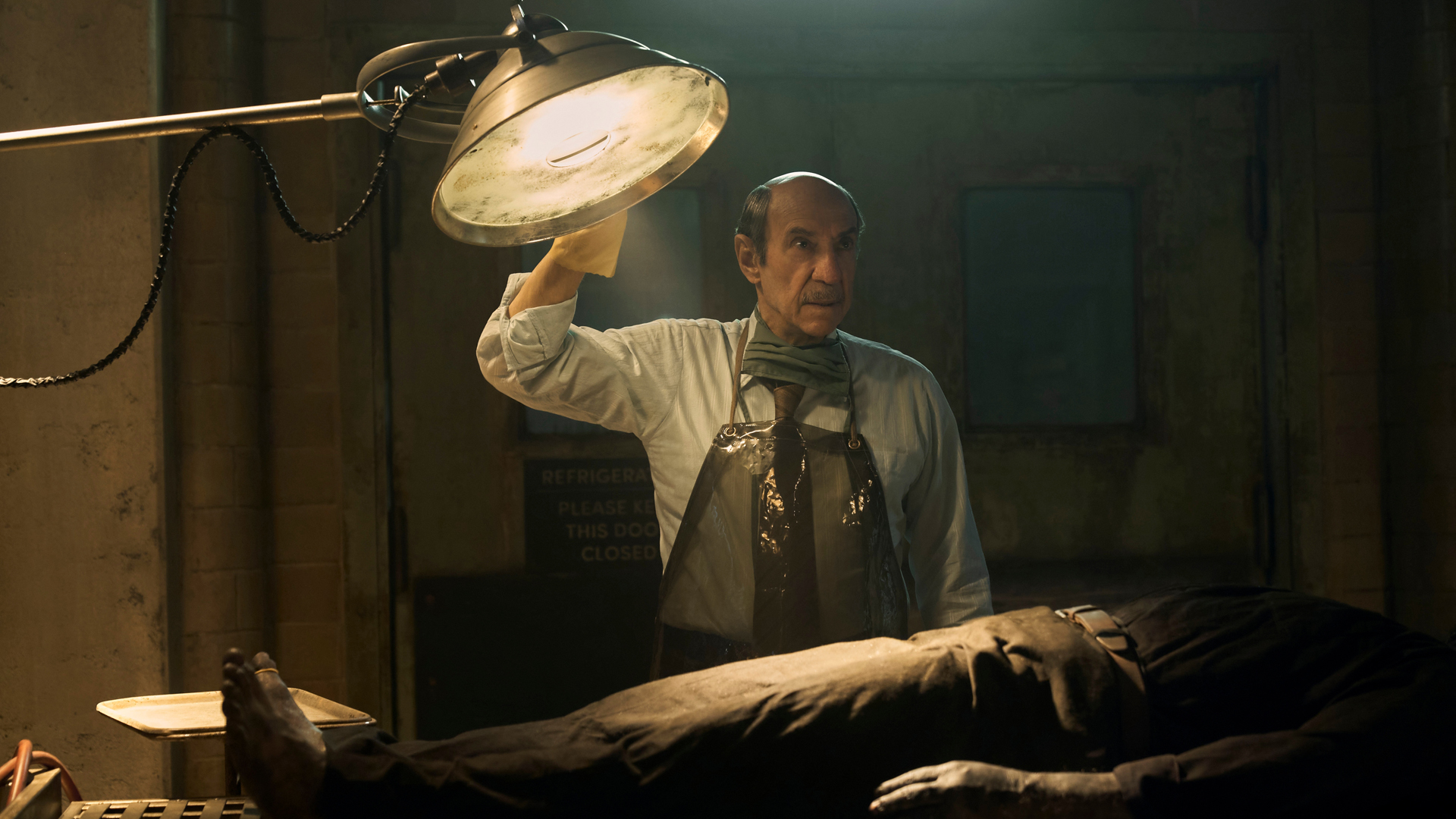 Carl Winters stands over a corpse and shines light on it in an autopsy on Netflix