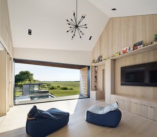 timber clad interior of Sagaponack house with open view to countryside