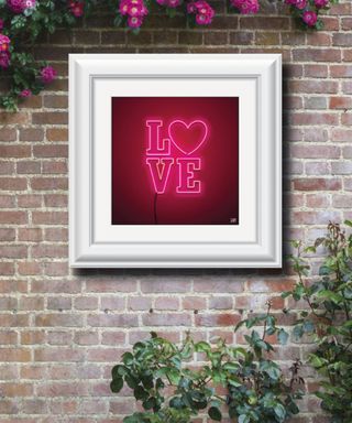 outdoor wall art in frame on brick wall