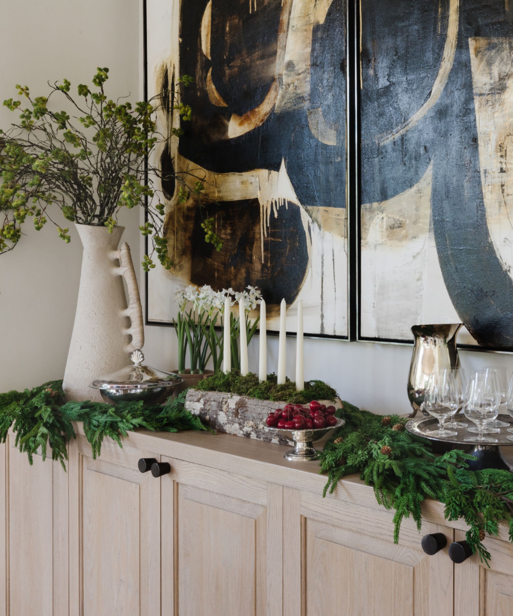 Sideboard decorated for Christmas with garlands, candles and bowls of fruit